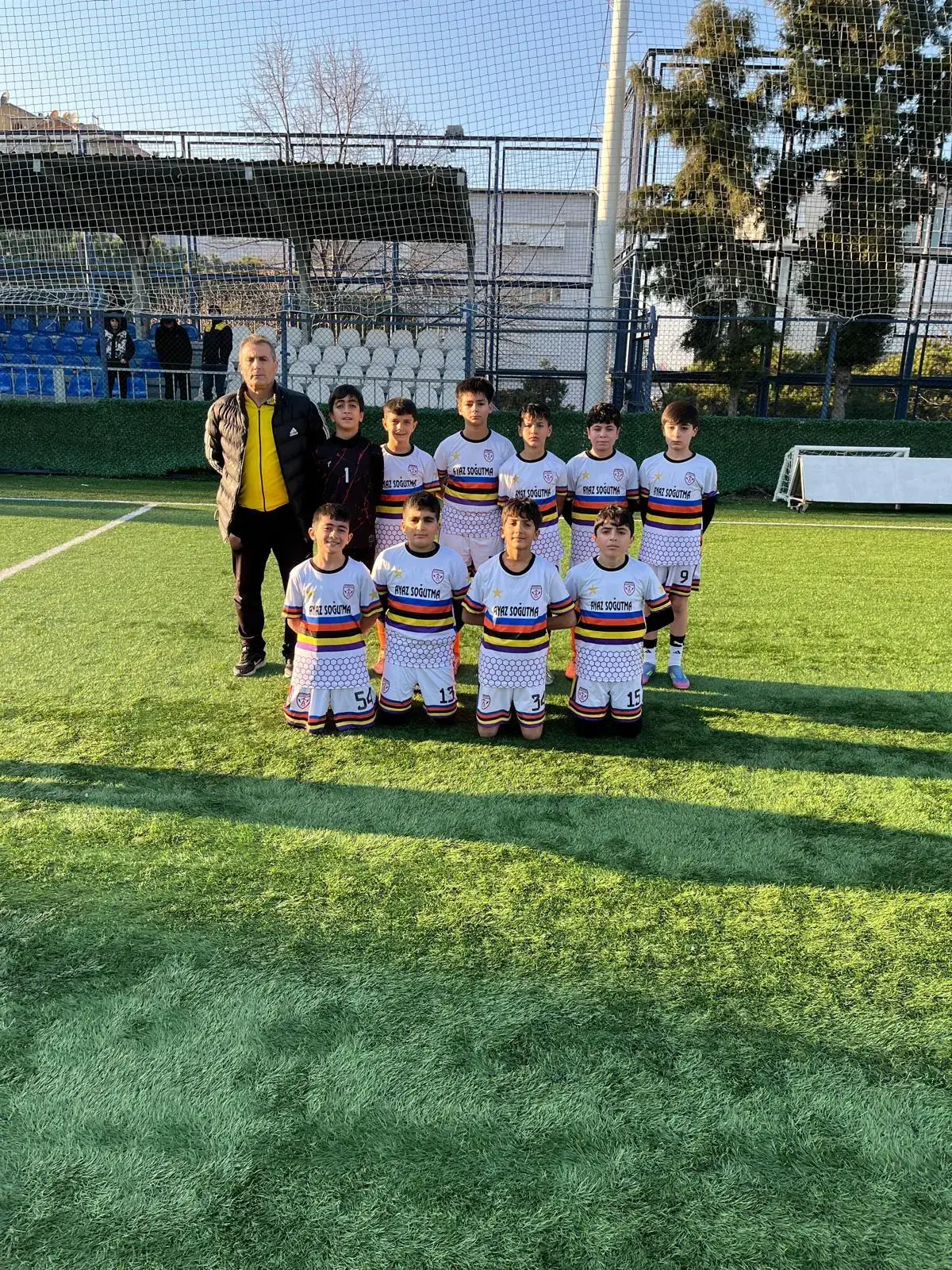 U12 2014 yaş grubu güneşli sahada takım pozu